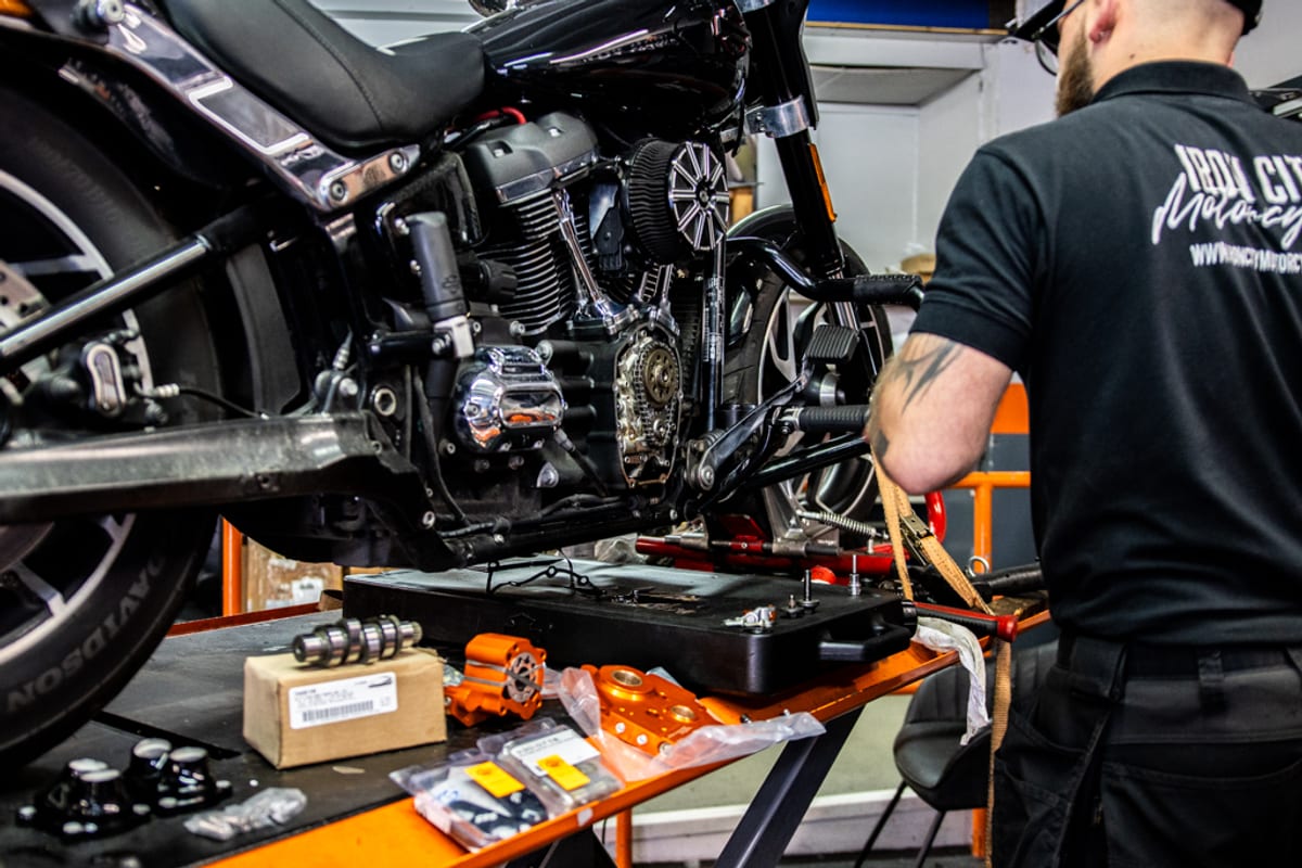 A Harley-Davidson on a workshop lift with the battery tray pulled for service
