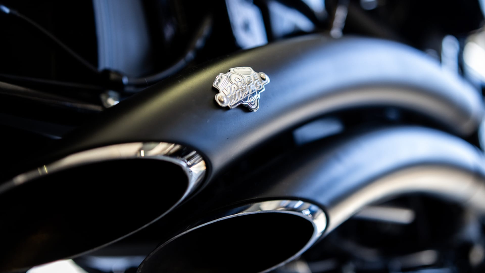 Vance & Hines Power Duals matte-black exhaust on Harley-Davidson with V&H badge medallion